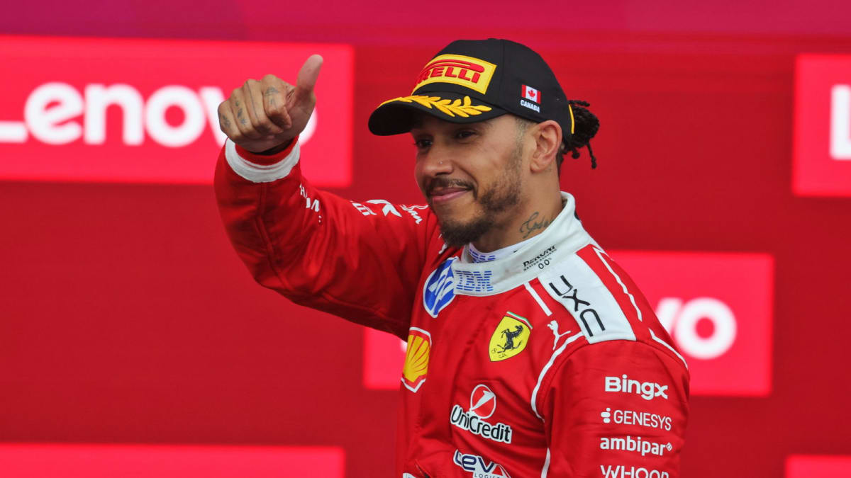 Lewis Hamilton celebrating on podium in Ferrari racing suit after second place finish Montreal