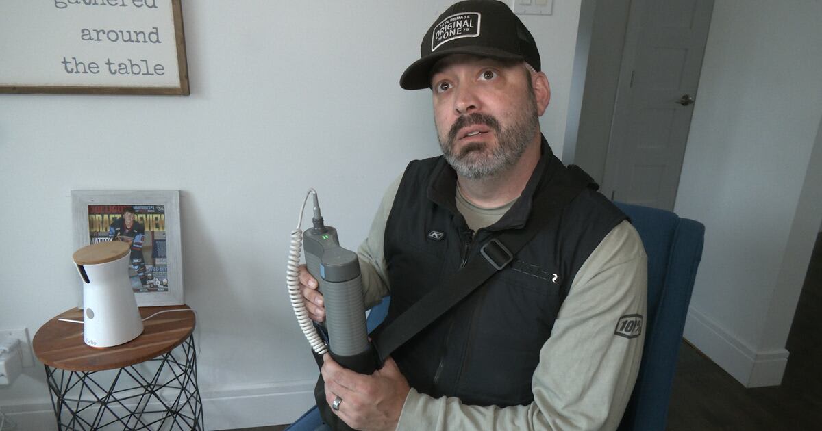 Francesco Colosimo holding portable Optune Gio cancer treatment device while smiling with family