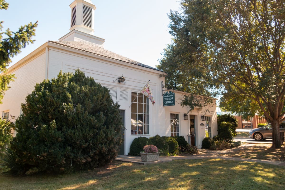 Exterior of small town municipal building with donation collection boxes for community food pantry program