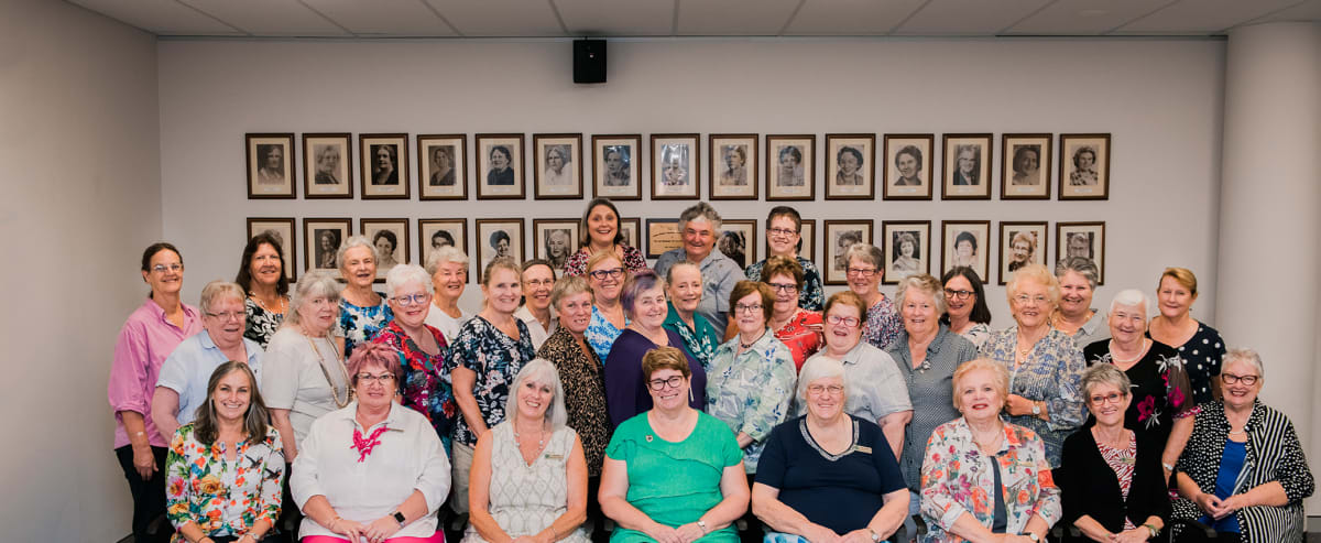 Volunteers serving freshly baked scones with jam and cream at busy tea room counter
