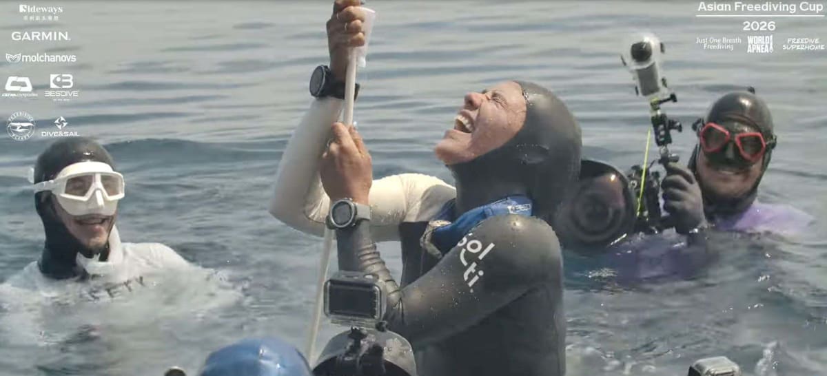 Freediver Enchante Gallardo descending vertically underwater along a guide rope during record dive