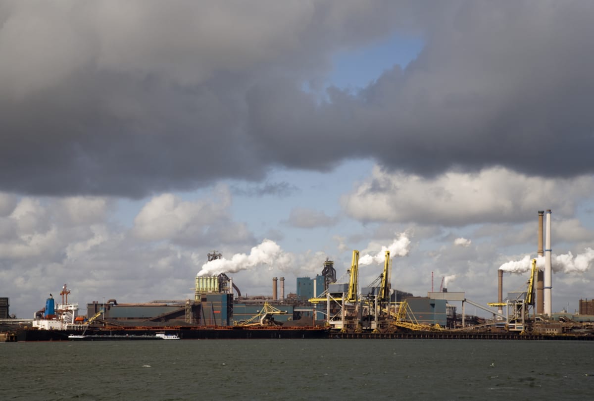 Large industrial steel manufacturing plant with blast furnaces against cloudy sky in IJmuiden, Netherlands