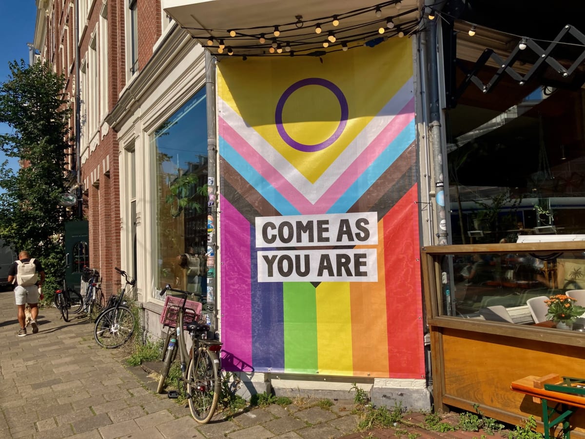 Colorful boats filled with Pride celebrants floating along Amsterdam's historic canals during annual celebration