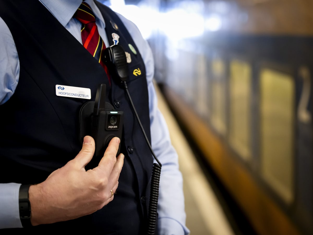 Dutch train conductor wearing bodycam device on uniform while working aboard passenger train