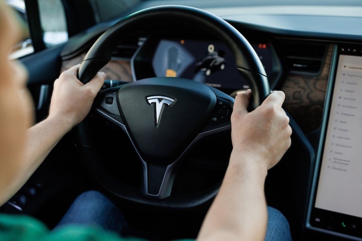 Tesla electric vehicle driving on European road with advanced driver assistance technology