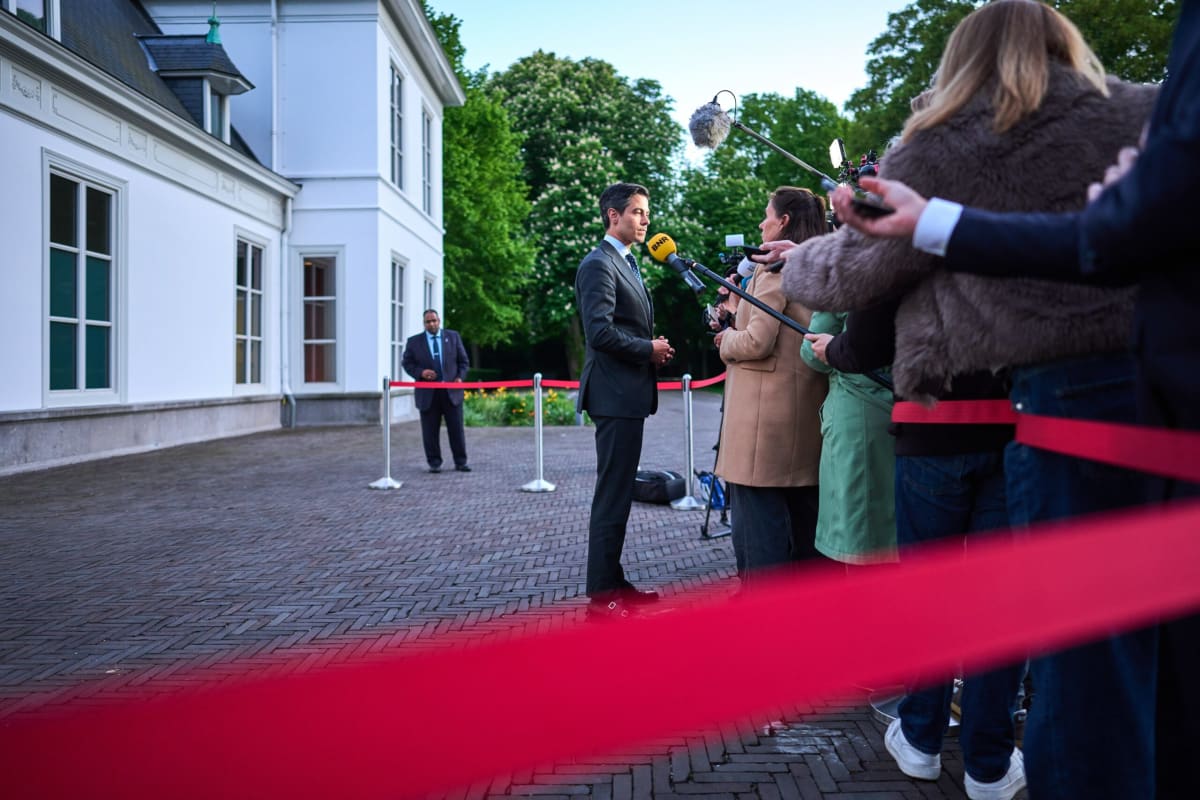 ** Dutch Prime Minister Rob Jetten speaking with local government officials at meeting table