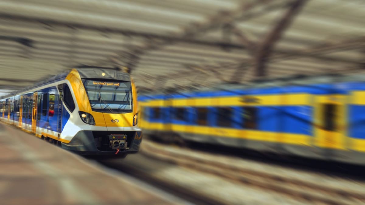 Modern Dutch NS train at station platform welcoming passengers aboard