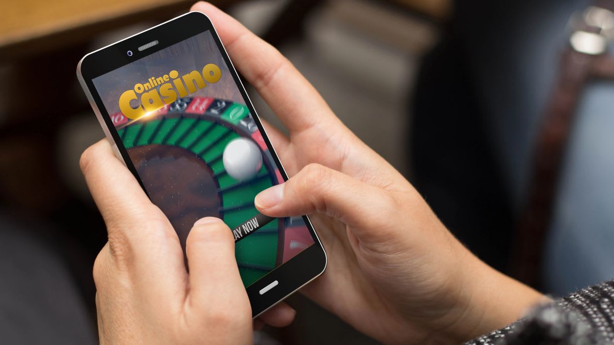 Person using smartphone with gambling app, representing Dutch online betting concerns and new protective measures