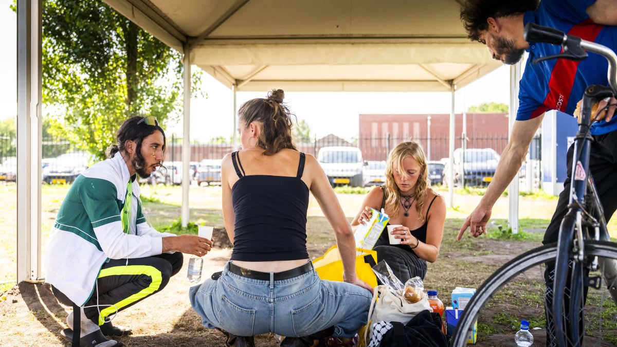 Volunteers distributing food and water to people gathered outside Ter Apel asylum reception center in the Netherlands