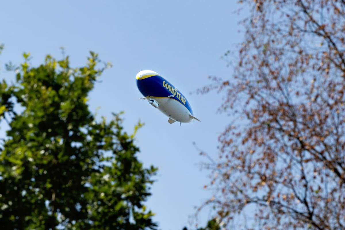 German zeppelin airship floating in blue sky above Dutch landscape measuring air quality