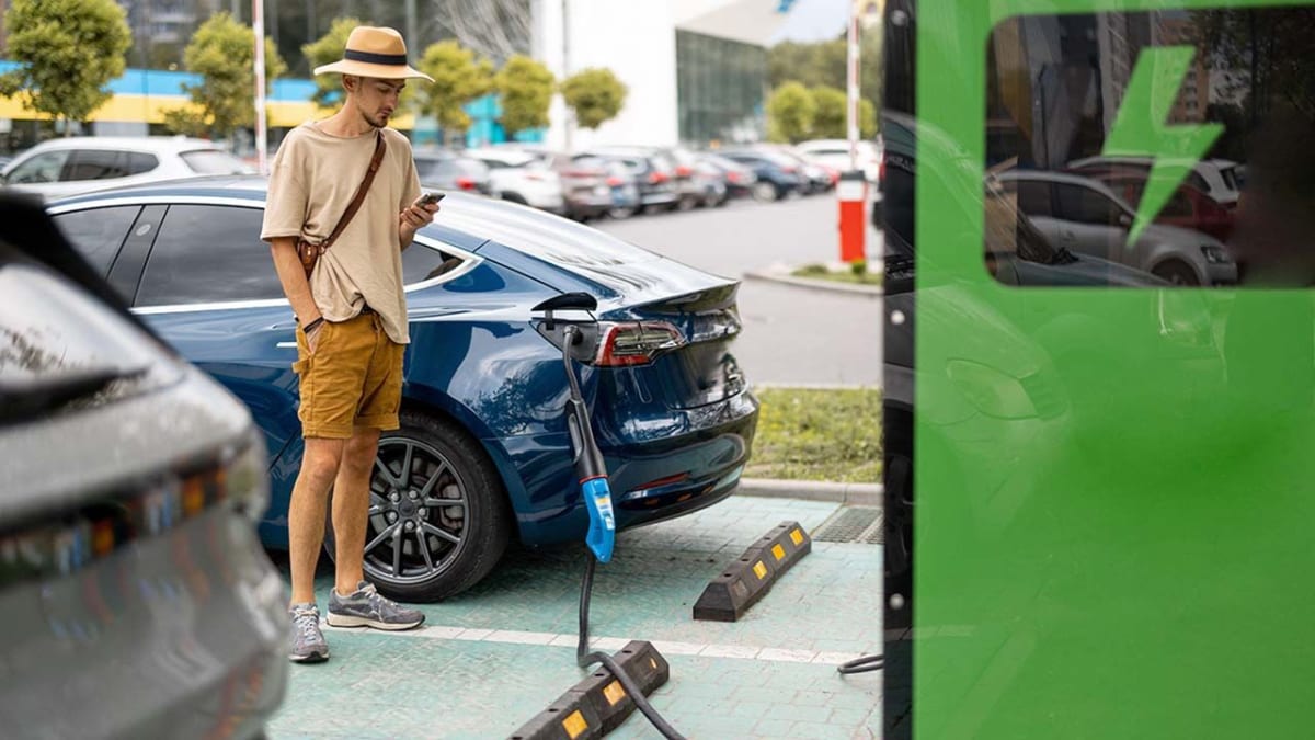 Electric vehicles plugged into charging stations at a modern service area