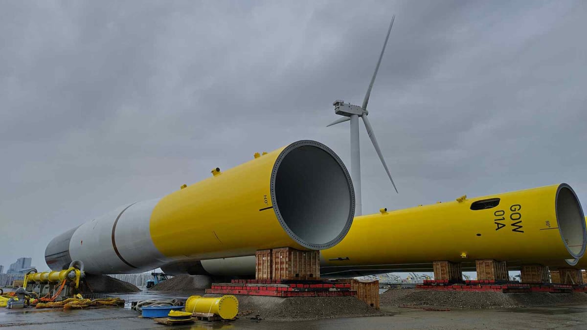 Modern wind turbines spinning against blue sky, representing breakthrough in century-old energy harvesting formulas