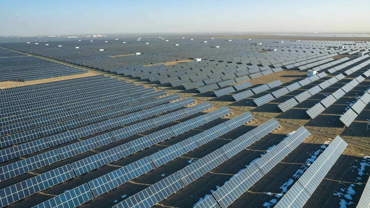 Aerial view of wind turbines and solar panel arrays across rural Ethiopian landscape under bright sun