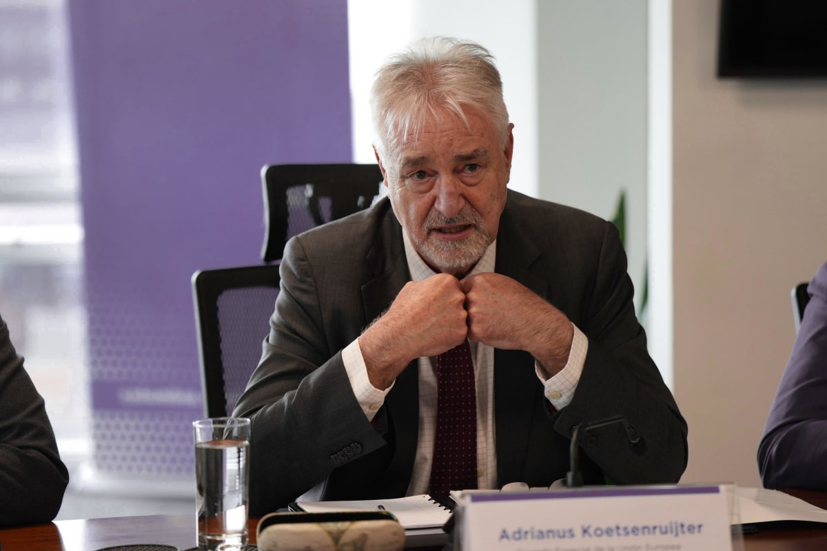 Colombian farmers working in green fields with mountains in background, representing rural development and peace