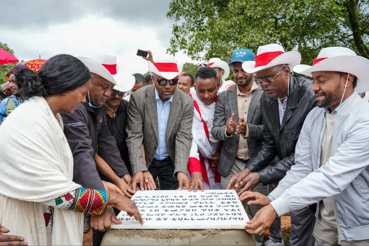 Foundation stone ceremony for new homes in rural Ethiopian community with bank officials and local residents