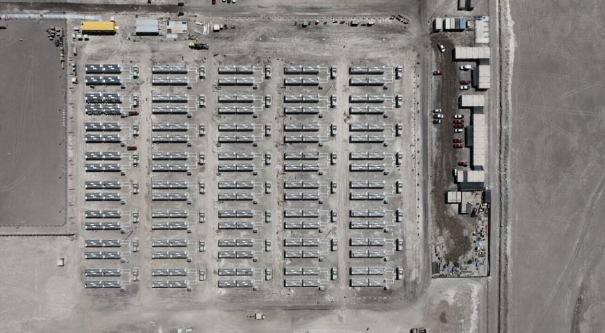Large-scale battery energy storage facility with solar panels in Chilean desert landscape