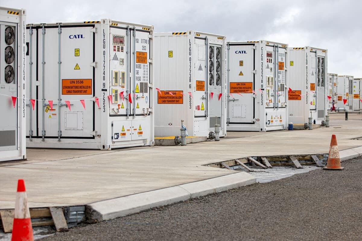 Large white battery storage containers in rows at Western Australia's Collie facility against blue sky