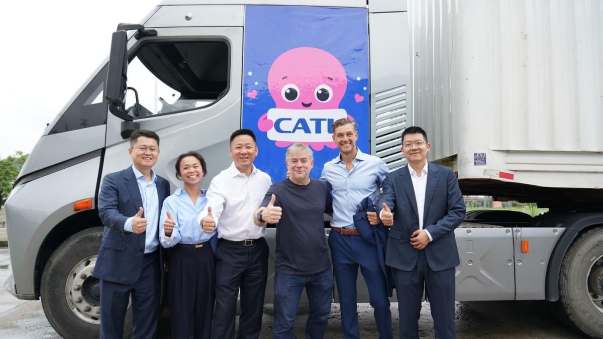 Electric semi-truck at battery swap station receiving fresh charged batteries from automated system