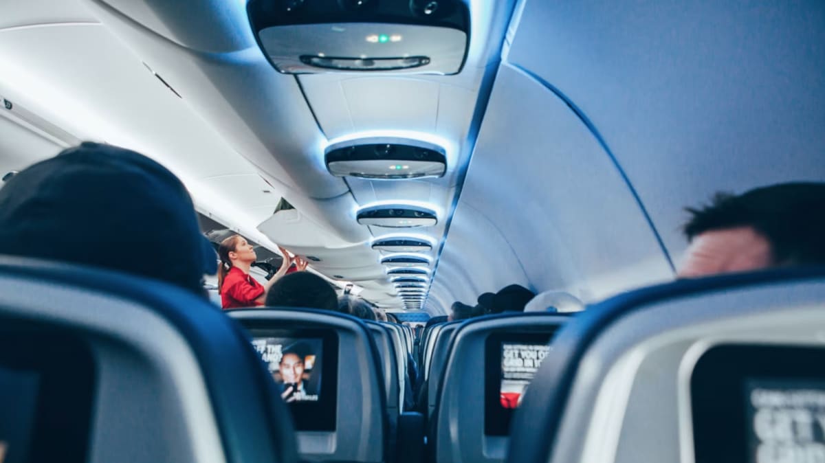 Modern commercial airplane flying through clear blue sky with connectivity signals