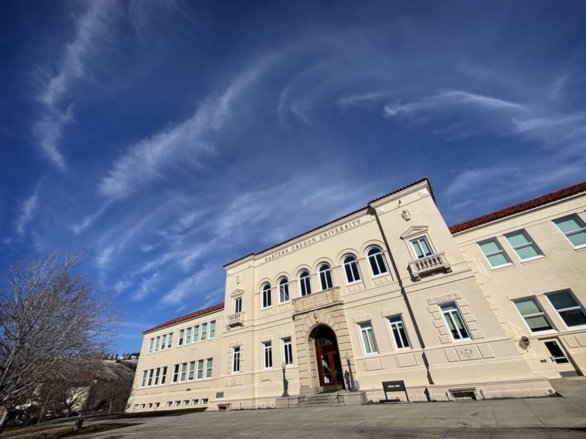 Mohtarama Mary Qazizada smiling in front of Eastern Oregon University campus building