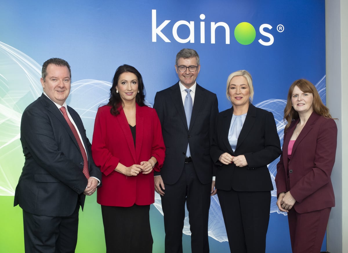 Business leaders and government ministers standing together at Kainos headquarters in Belfast announcing job creation