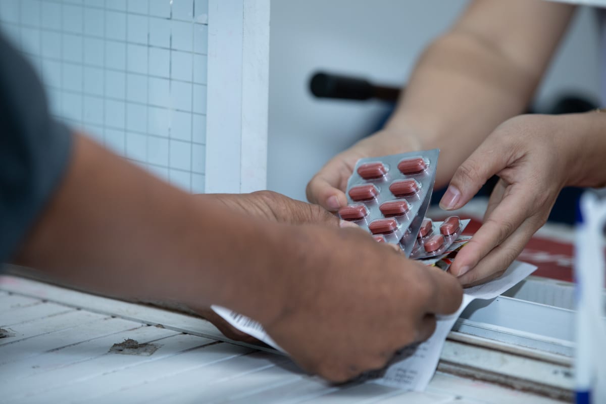 Healthcare worker administers tuberculosis medication to patient at hospital in Vietnam