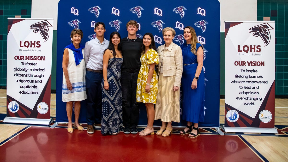 Four La Quinta High School students smile together holding scholarship awards at ceremony