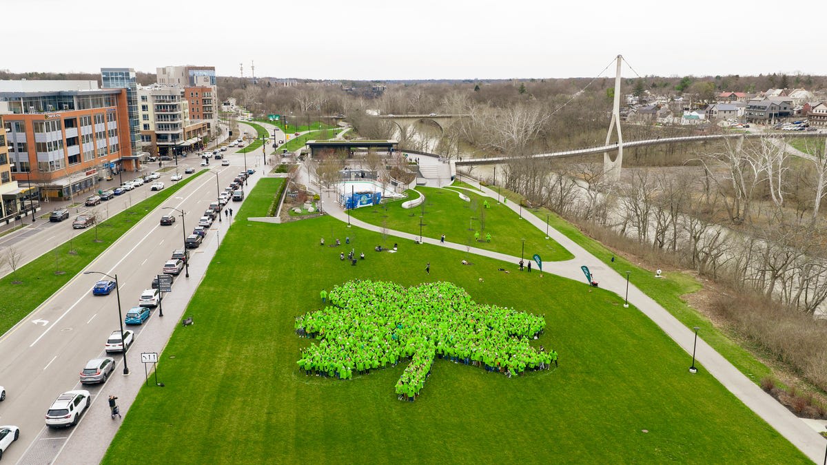 Aerial view of over one thousand people dressed in green forming giant shamrock shape