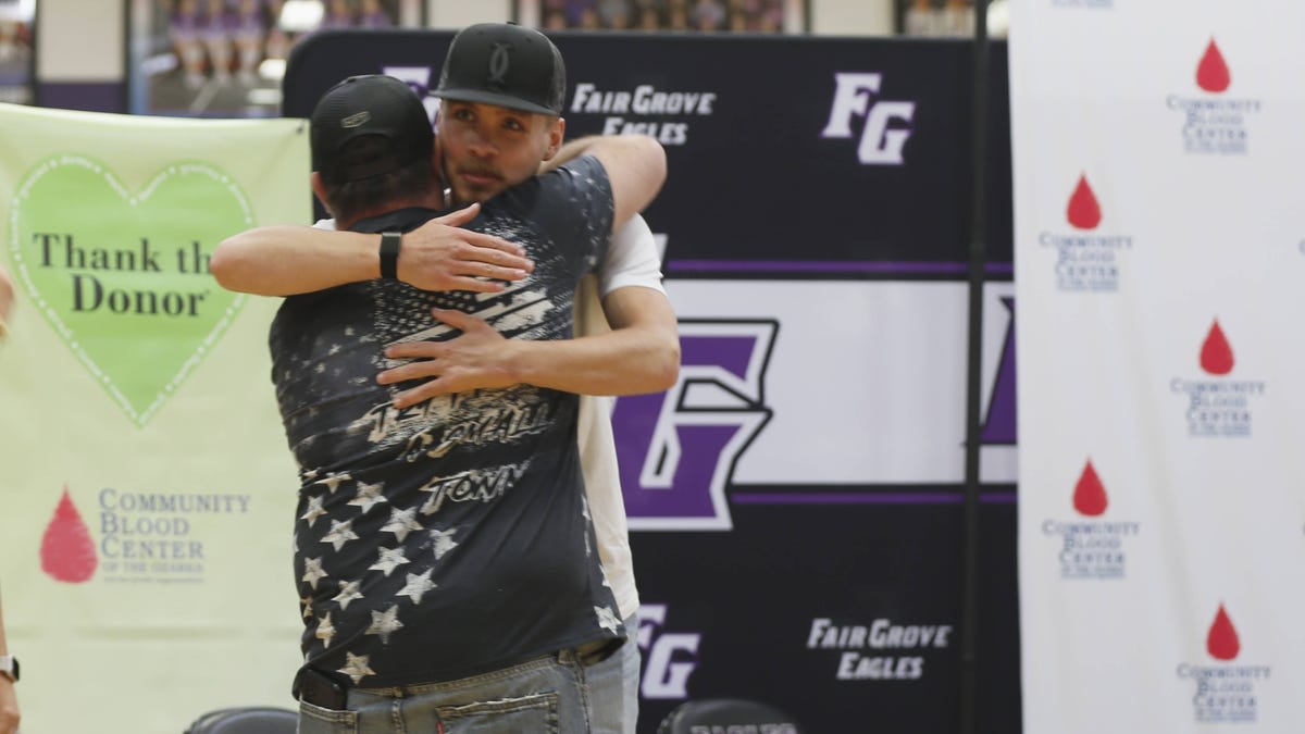 Cooper Roy speaking to packed gymnasium of Fair Grove High School students about his recovery