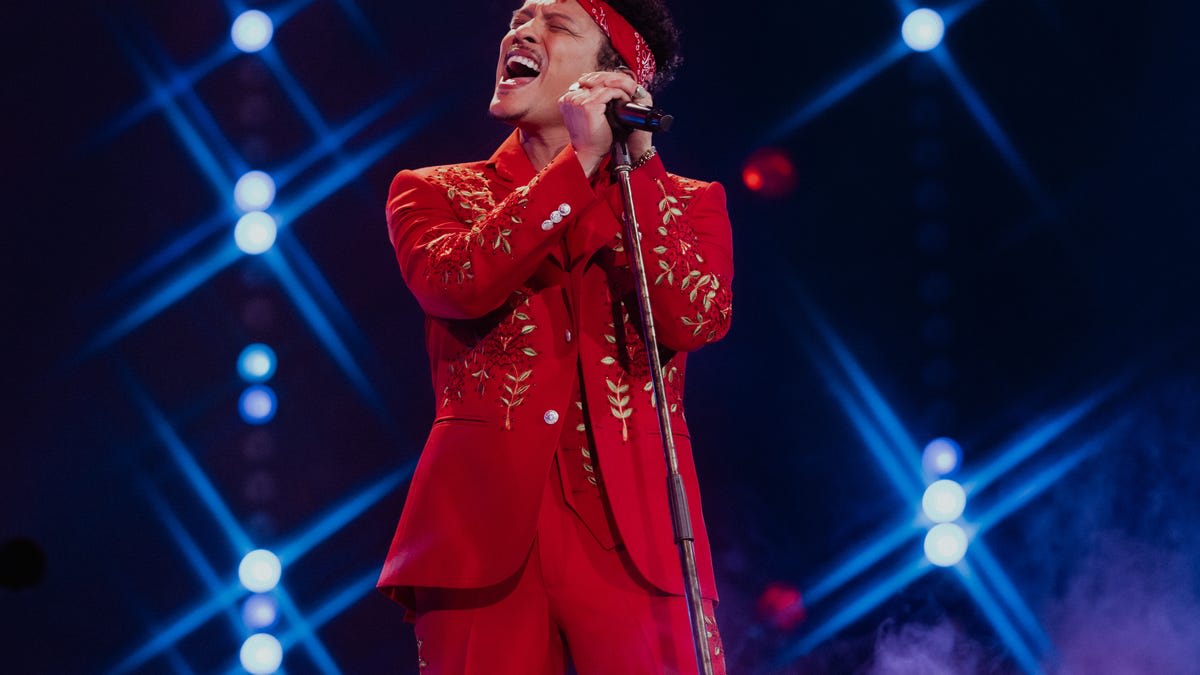 Bruno Mars performing onstage in red embroidered suit during The Romantic Tour opener