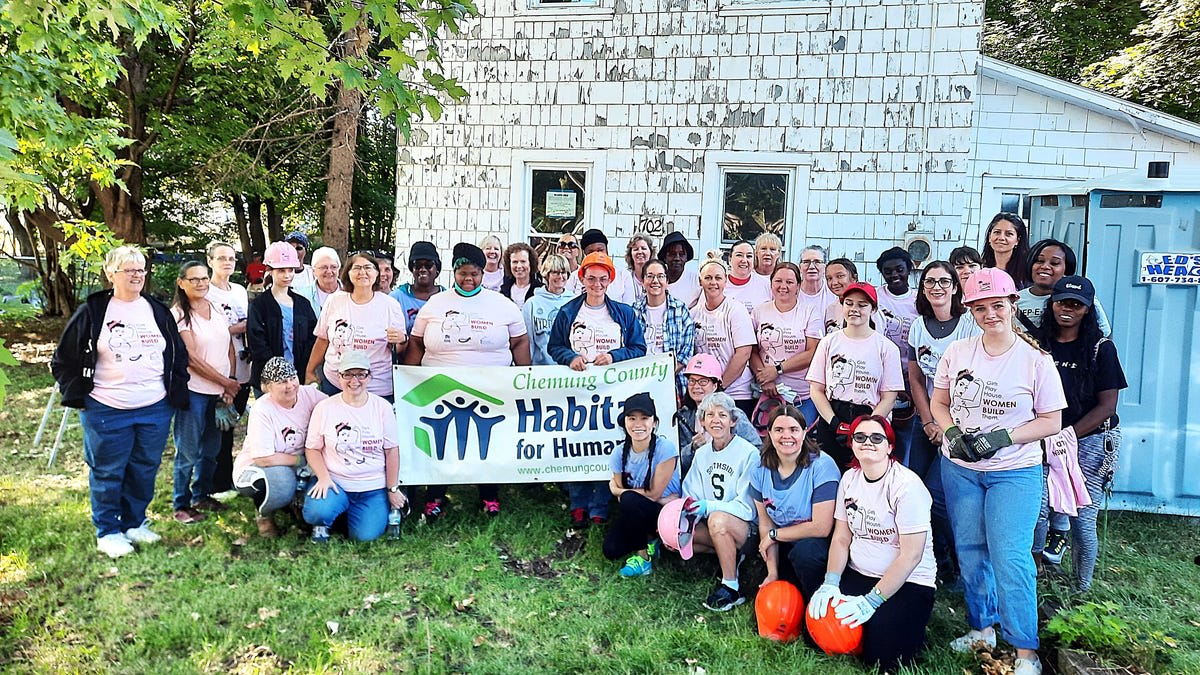 Female volunteers in matching t-shirts working together on home renovation project for Habitat for Humanity