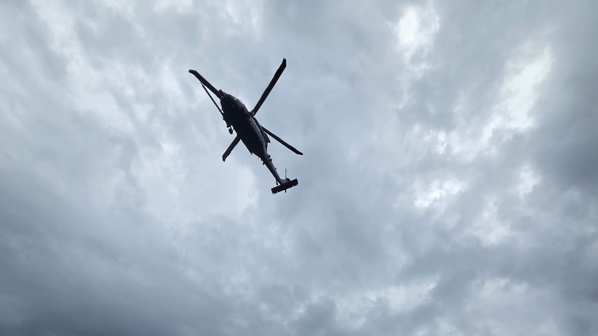 Air Force HH-60W Jolly Green II helicopter hovering over ocean during rescue operation