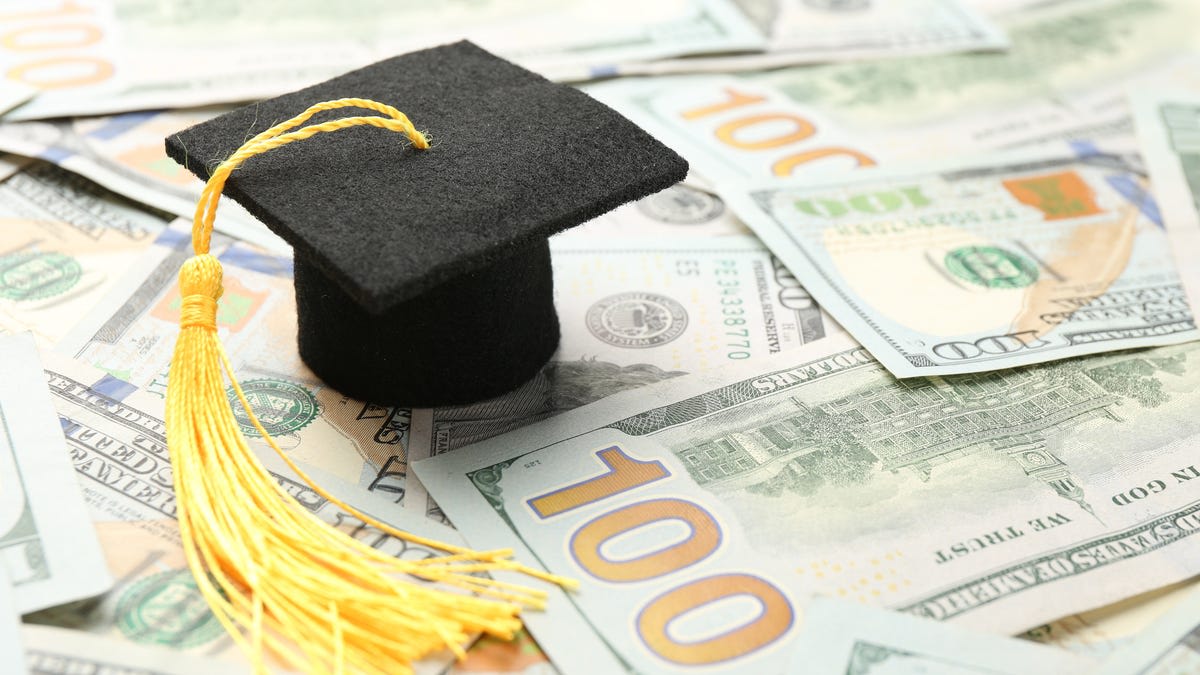 Group of high school graduates in caps and gowns celebrating scholarship awards at ceremony