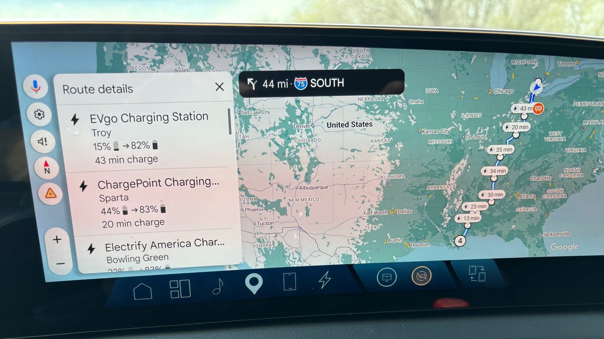 Cadillac Optiq electric SUV charging at highway rest stop during long-distance road trip
