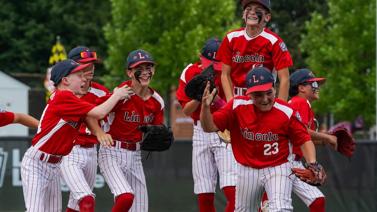 Young baseball pitcher celebrating championship victory with teammates on field