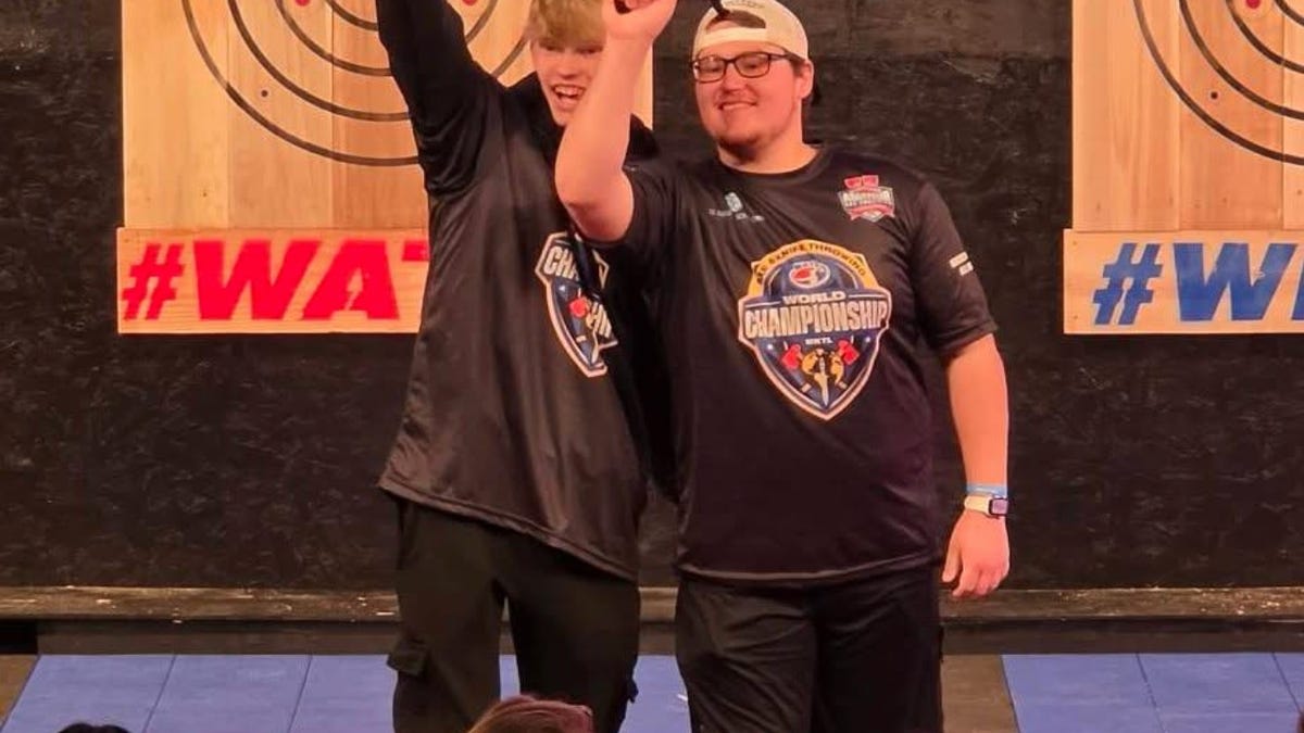 ** Two young men holding competition throwing knives after winning world championship title