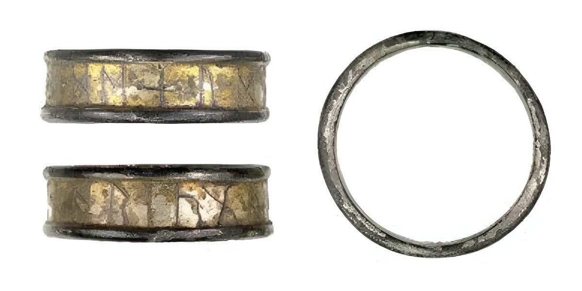 Ancient Anglo-Saxon gold ring displaying runic inscriptions around its surface from medieval England