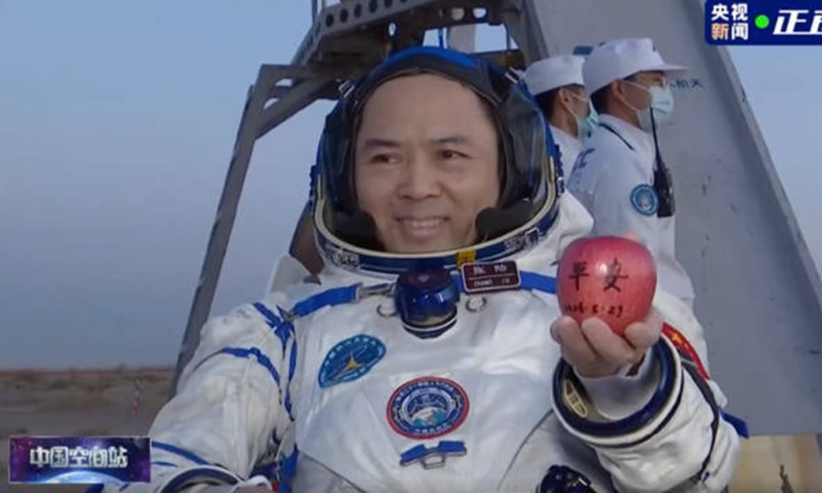 Chinese astronaut Commander Zhang Lu exits space capsule in Inner Mongolia holding apple from space