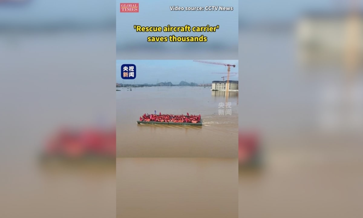 Large motorized floating bridge extending across floodwaters to evacuate people from surrounded school campus
