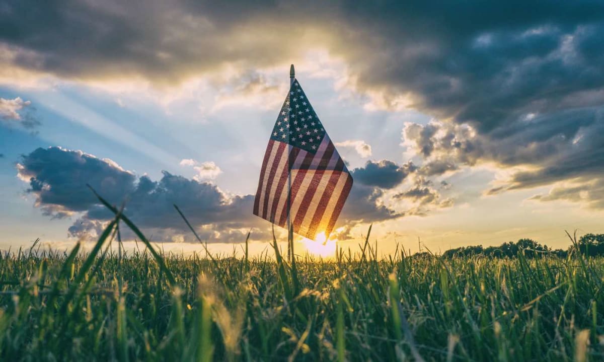** American flag waving against blue sky celebrating 250 years of independence and innovation