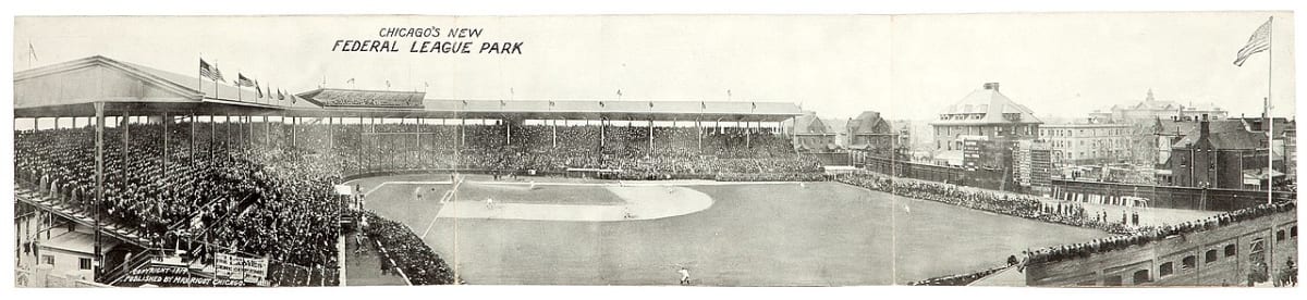 Historic Wrigley Field baseball stadium showing iconic ivy-covered outfield walls and hand-operated scoreboard