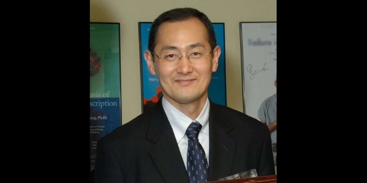Japanese scientist Shinya Yamanaka in laboratory coat examining stem cell research materials
