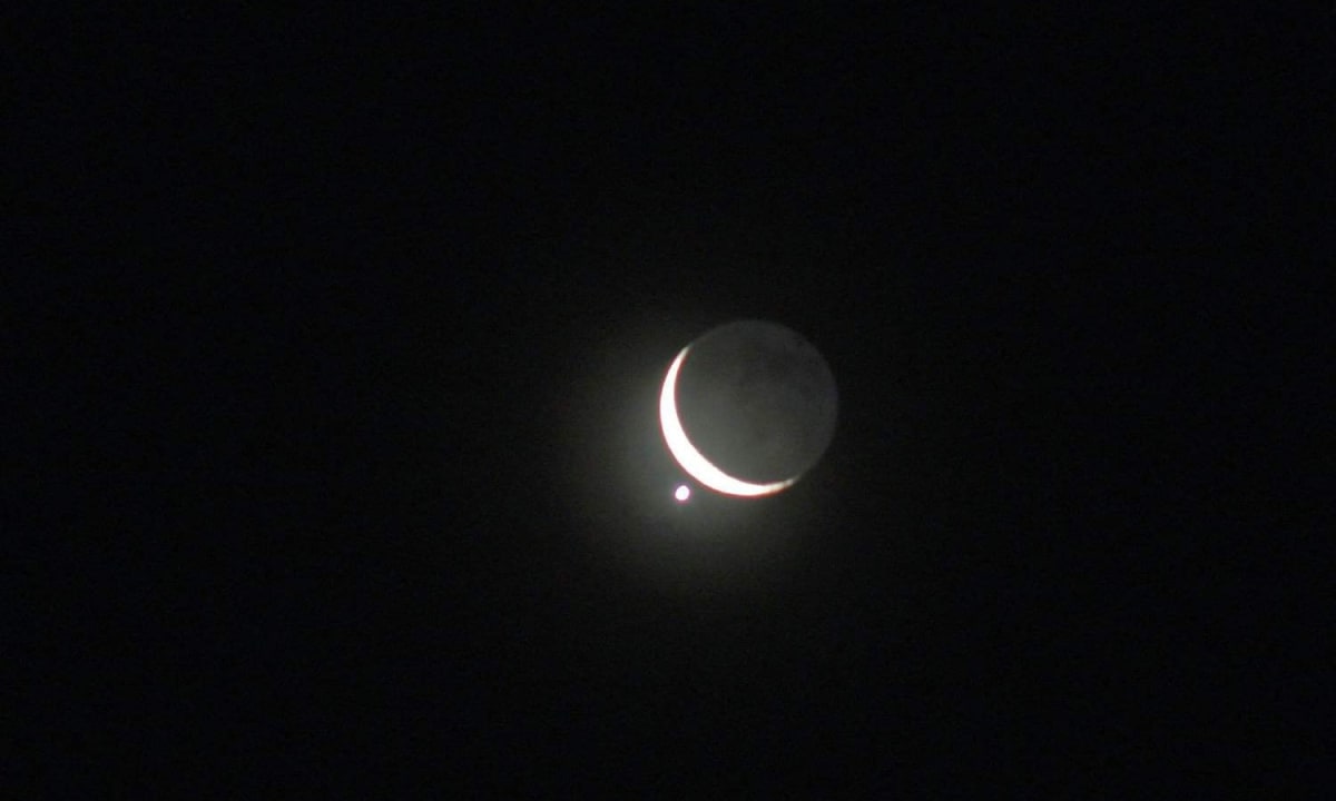 Jupiter and Venus aligned with crescent moon in dark western sky after sunset