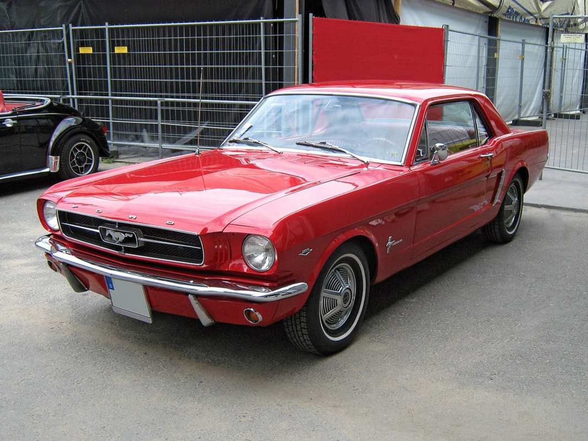 ** First generation Ford Mustang from 1964 in classic profile view showing iconic long hood design