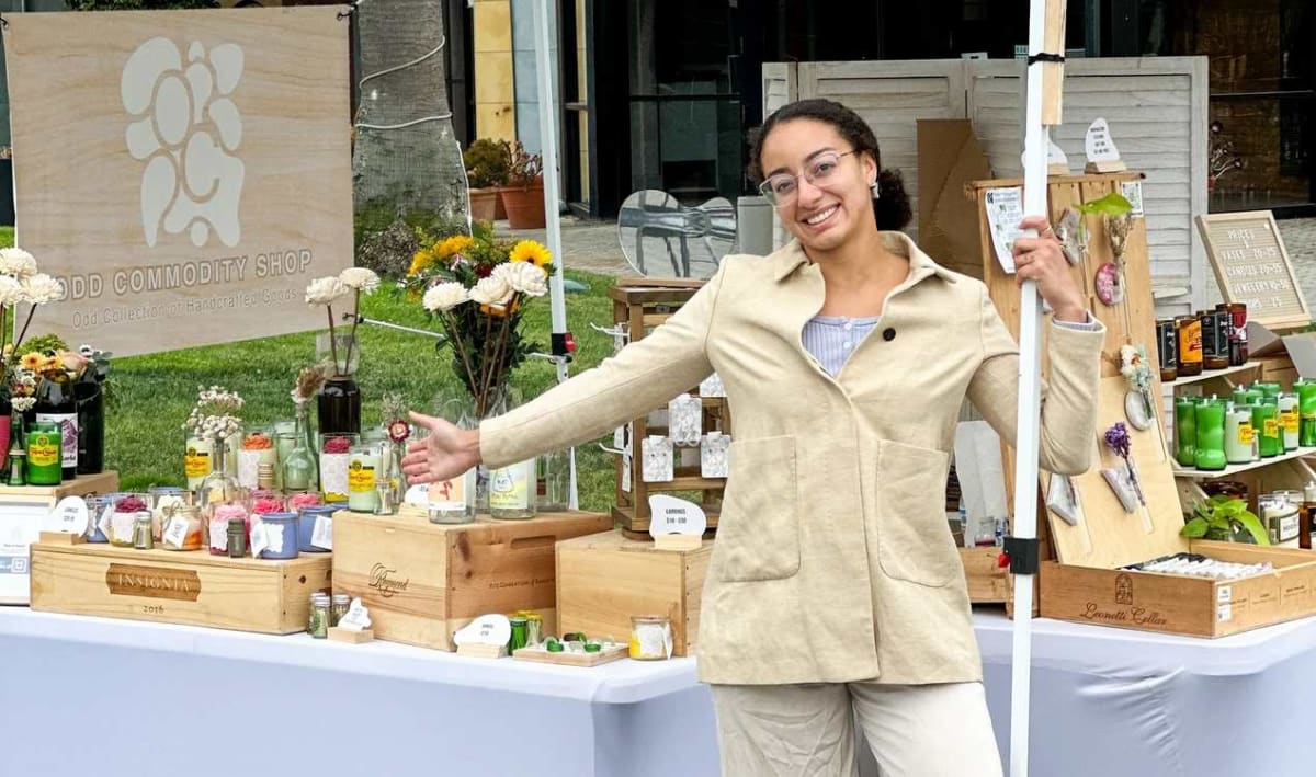 Sydney Jones standing in front of her Odd Commodity artisan stall displaying handmade jewelry