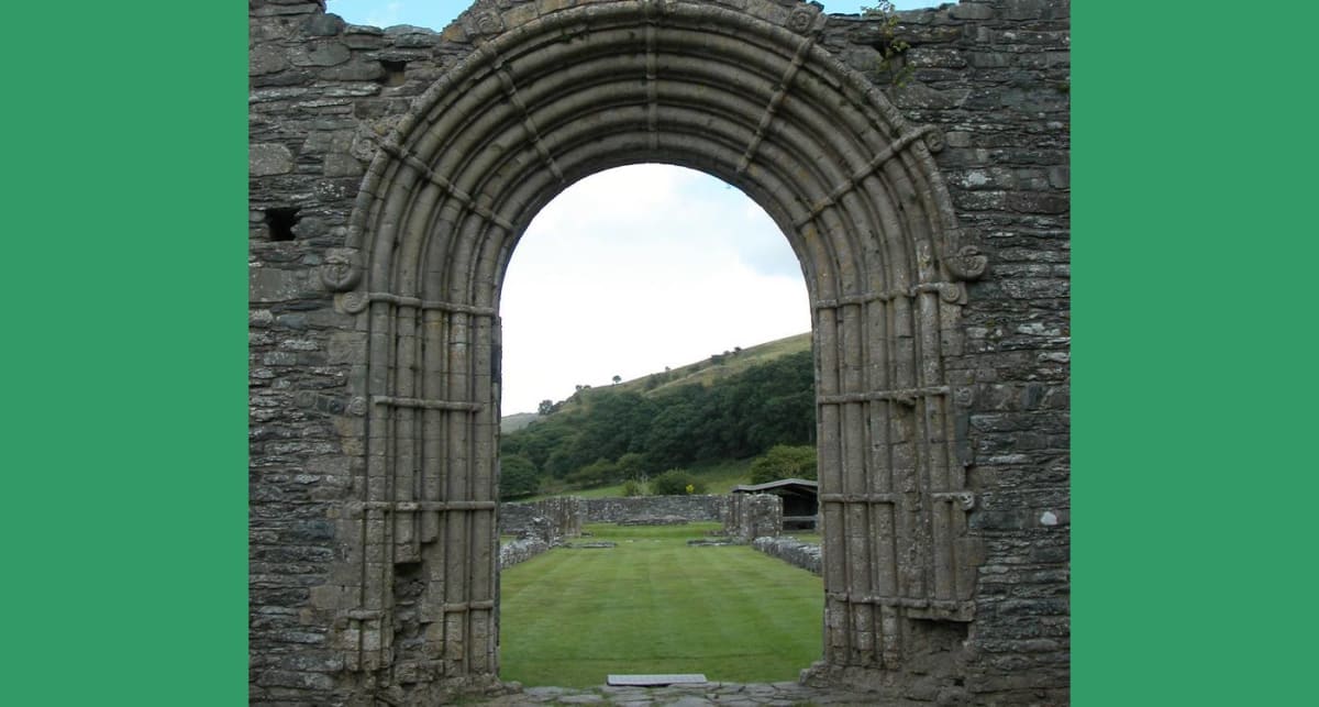 Stone archway entrance to ancient Strata Florida Abbey ruins in Welsh countryside