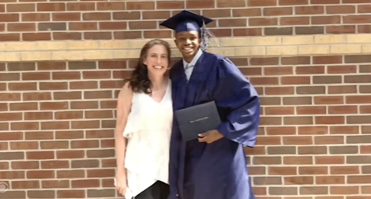 Dr. Mary Austin embracing Dylan in cap and gown at his high school graduation ceremony