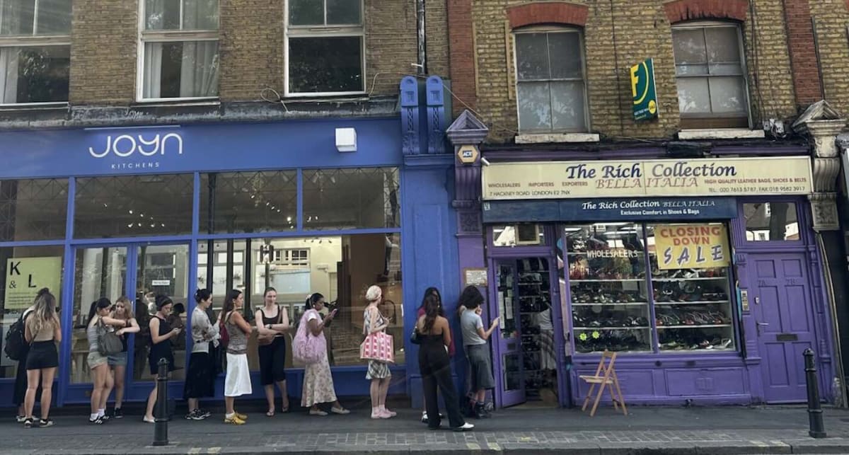 Smiling father and daughter standing outside Rich Collection Italia vintage shoe shop in London