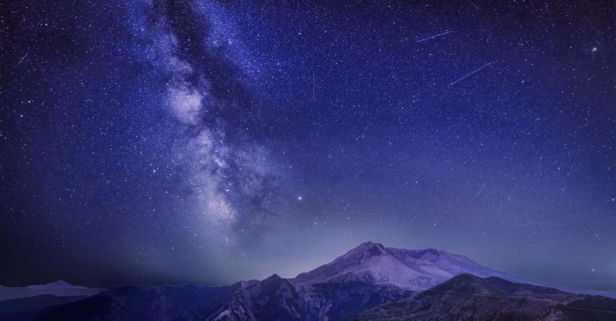 Streaking meteor shower lights up dark night sky with multiple shooting stars visible