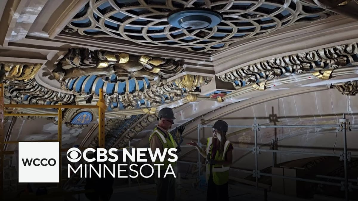 Gold stencil artwork emerging from beneath paint on ornate basilica ceiling arch in Minneapolis